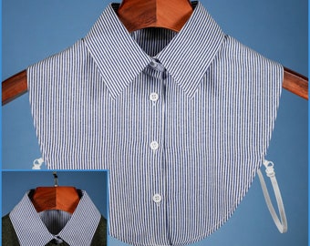May include: A blue and white striped detachable collar with a button closure. The collar is made of cotton and has a rounded shape. It is attached to a white elastic band.