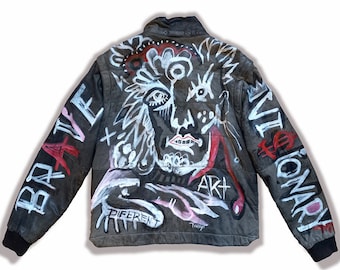 Könnte beinhalten: Schwarze Lederjacke mit handgemaltem Design, das ein Gesicht, abstrakte Formen und die Wörter "Brave", "Art", "Different" und "Revolutionary" zeigt.