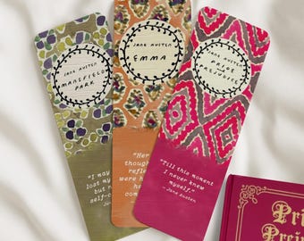 May include: Three Jane Austen themed bookmarks with quotes. The bookmarks feature floral and geometric patterns in green, orange, and pink. Each bookmark has a title and quote from "Mansfield Park", "Emma", and "Pride and Prejudice".