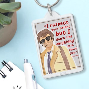 May include: A white acrylic keychain with a cartoon illustration of a man wearing sunglasses and a suit. The text on the keychain reads "I respect your talent but I don't like anything else about you." - COLUMBO