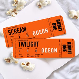 May include: Two orange ODEON movie tickets with the movies "Scream" and "Twilight" printed on them. The tickets have the words "Admit One" and popcorn scattered around them.