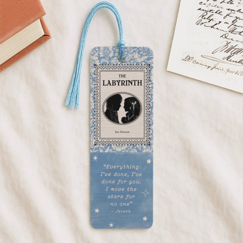 K&ouml;nnte beinhalten: Blau-wei&szlig;er Lesezeichen mit dem Titel "The Labyrinth" und einer Silhouette von zwei Charakteren. Das Lesezeichen hat eine hellblaue Quaste und ein Zitat aus dem Film. Ein Buchzubeh&ouml;r.