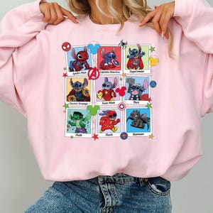 a woman wearing a pink sweatshirt with cartoon characters on it