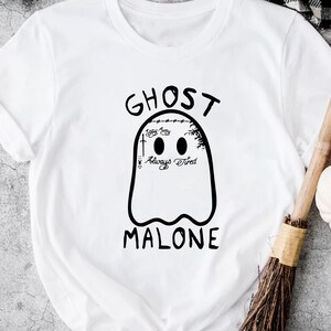 Op de afbeelding: Wit T-shirt met een zwarte geestenafbeelding. De geest heeft de tekst "Stay Away", "Always" en "Tired" erop geschreven. De tekst "GHOST MALONE" staat boven en onder de geest.