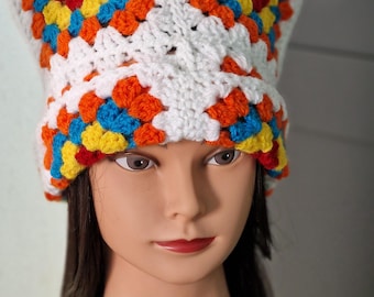 May include: A white crocheted hat with a colorful geometric pattern in shades of red, orange, yellow, and blue.