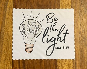 May include: White square cloth with a light bulb design and the text "Be the light Mat. 5:14".