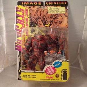 May include: A red and black action figure of Slag, a chemically created volcanic villain from the Image Universe WildC.A.T.s comic book series. The figure is packaged in a plastic blister pack with a cardboard backing. The packaging includes the Image Universe logo and the text "New!" and "ASST. NO. 11800 STOCK NO. 11802".