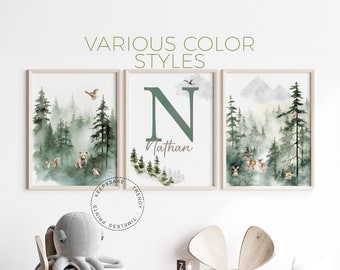 May include: Three framed watercolour prints with a woodland theme. The prints feature a bear, a deer, and a letter N with the name Nathan. The prints are hung on a white wall above a wooden table and chairs.