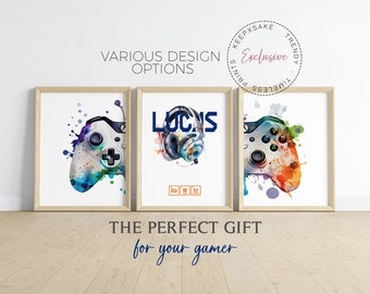 May include: Three framed prints with a gamer theme. The prints feature a watercolor style design of a video game controller, a pair of headphones, and the word "LOCNS" with the chemical symbols for Gallium, Manganese, and Erbium. The text "THE PERFECT GIFT for your gamer" is below the prints.