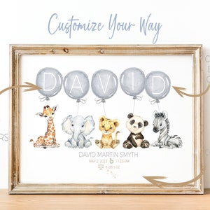 May include: A framed watercolor print featuring the name "DAVID" in gray balloons above animal illustrations. The print includes a giraffe, elephant, lion, panda, and zebra. Text at the bottom reads "DAVID MARTIN SMYTH" with birth details.