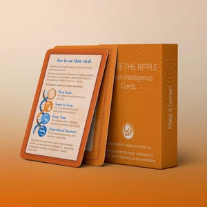 Può includere: Una scatola e carte arancioni con il testo "Create the Ripple Human Intelligence Cards". Le carte hanno istruzioni e sono impilate accanto alla scatola. La scatola e le carte sono su uno sfondo arancione chiaro.