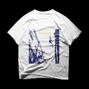 May include: White t-shirt featuring a blue and gold graphic design. The design includes a silhouette of a person climbing a building, with the text "Elliot Smith" in gold.