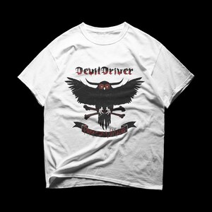 Puede incluir: Camiseta blanca con un gráfico desgastado de un búho negro con ojos rojos y una pancarta que dice "PRAY FOR VILLAINS". El texto "DevilDriver" está encima del búho en una fuente gótica. La camiseta tiene mangas cortas y cuello redondo.