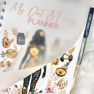 May include: A spiral-bound planner with the title "My Diet & Fitness Planner" in a script font. The pages feature illustrations of healthy foods, exercise equipment, and a silhouette of a person. Tabs are labeled "Today" and "Start/Goals".