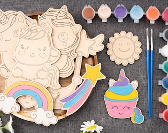 May include: A wooden craft kit featuring unicorn, rainbow, star, and cupcake shapes. The kit includes paint, brushes, and a wooden tray.