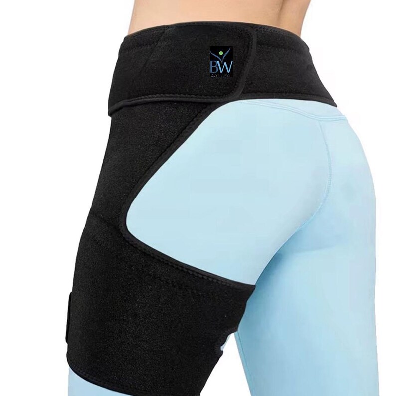 May include: Black hip and thigh support wrap with a velcro closure and the letters "BW" on the upper portion. The wrap is worn over light blue leggings.