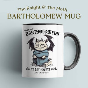 Peut inclure: Mug en céramique blanche avec une anse et un bord noirs. Il présente une illustration de dessin animé d'une créature avec des ailes de chauve-souris et le texte "Fear not BARTHOLOMEW!" et "EVERY DAY HAS ITS DOG." Le mug est étiqueté "BARTHOLOMEW MUG."