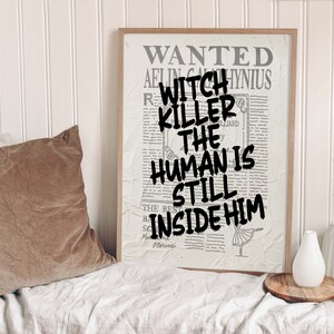 May include: A framed poster with a distressed newspaper background. The poster reads "WANTED AELIN GALANTHIS WITCH KILLER THE HUMAN IS STILL INSIDE HIM".