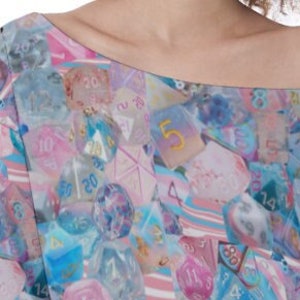 May include: A pink and blue off-the-shoulder top with a pattern of dice and numbers. The dice are translucent and have different numbers on them.