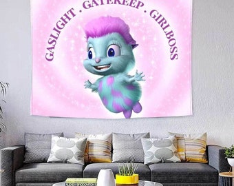 Puede incluir: Un tapiz de pared rectangular que muestra una criatura peluda de color azul claro con pelo y manchas rosas. El fondo es un degradado rosa suave con efecto brillante. El texto GASLIGHT . GATEKEEP . GIRLBOSS está impreso en morado en arco.