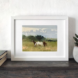 Puede incluir: Una pintura enmarcada de tres caballos en un campo. Los caballos son marrones y blancos, y el campo es verde. El cielo es azul y nublado. La pintura est&aacute; en un marco blanco.