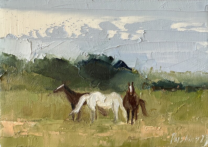 Puede incluir: Una pintura de tres caballos en un campo con una cordillera de monta&ntilde;as en el fondo. Los caballos son marrones y blancos, y el cielo es de un azul claro con nubes blancas.