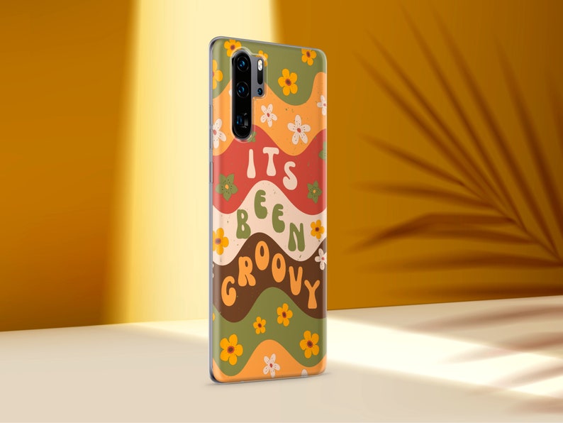 May include: A phone case with a groovy 70s style design. It features a wavy pattern in shades of orange, red, green, and brown with yellow flowers. The text "It's Been Groovy" is printed in a retro font.