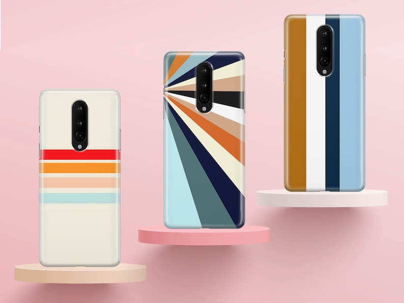 K&ouml;nnte beinhalten: Drei Handyh&uuml;llen mit verschiedenen geometrischen Mustern. Die erste H&uuml;lle hat einen wei&szlig;en Hintergrund mit horizontalen Streifen in Rot, Orange und Blau. Die zweite H&uuml;lle hat einen blauen Hintergrund mit einem strahlenf&ouml;rmigen Muster aus Streifen in Orange, Gelb und Wei&szlig;. Die dritte H&uuml;lle hat einen wei&szlig;en Hintergrund mit vertikalen Streifen in Braun, Wei&szlig; und Blau.