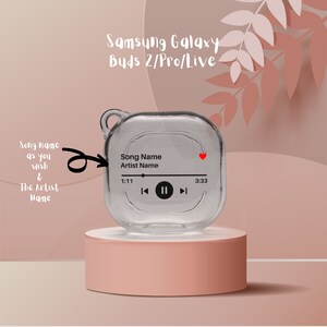 May include: A clear plastic case for Samsung Galaxy Buds 2/Pro/Live with a red heart icon and a music player interface showing "Song Name" and "Artist Name".