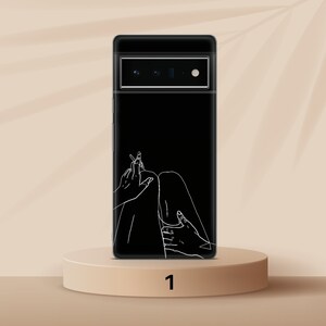 Puede incluir: Una funda de tel&eacute;fono negra con un dibujo de l&iacute;nea blanca de las piernas y las manos de una persona. La funda del tel&eacute;fono tiene una lente de c&aacute;mara negra.