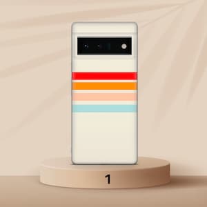 K&ouml;nnte beinhalten: Eine wei&szlig;e Handyh&uuml;lle mit einem bunten Streifenmuster. Die H&uuml;lle hat einen Ausschnitt f&uuml;r die Kamera und einen wei&szlig;en Hintergrund mit roten, orangen, gelben, rosa und blauen Streifen.