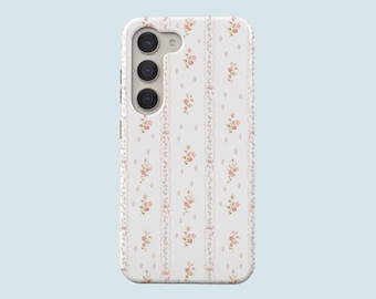May include: A white smartphone case featuring a repeating vertical pattern of delicate pink and orange floral sprigs interspersed with thin, ornate, light brown decorative lines that run the length of the protective cover.
