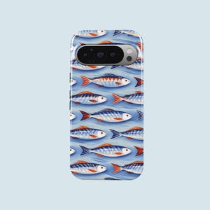 May include: A phone case featuring a repeating pattern of stylized fish in shades of blue, orange, and white. The fish are arranged on a light blue background, creating a nautical or aquatic theme. The case has a camera cutout.