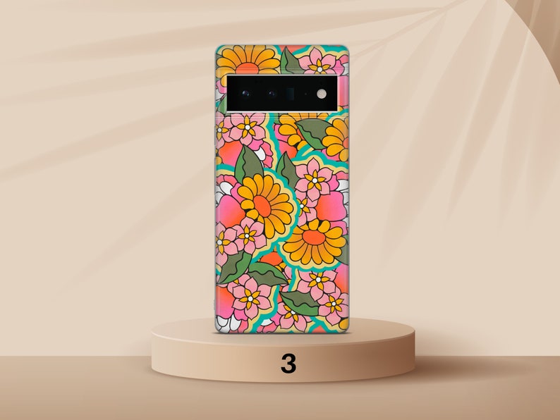 May include: A phone case with a retro floral pattern in shades of pink, yellow, green, and blue. The case features a variety of flowers and leaves.