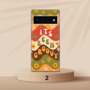 May include: A phone case with a retro design featuring wavy lines in shades of orange, red, green, and brown. The case has a floral pattern and the text "It's Been Groovy".
