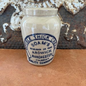 May include: A white ceramic mug with a black handle and the text "But First, Coffee" in a bold, black font. The mug is sitting on a wooden surface. The mug is 4 inches tall.