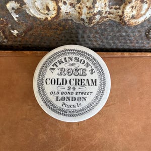 May include: A set of three ceramic mugs with a speckled, matte finish. The mugs are in shades of cream, light gray, and dark gray. Each mug has a simple, minimalist design and a rounded handle.