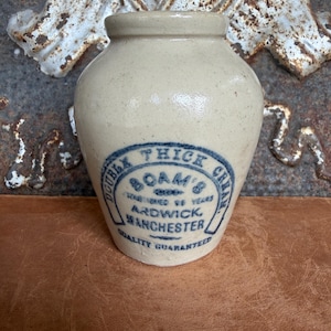 Peut inclure: Un pot en grès beige avec un corps arrondi et un col court. L'avant présente un texte imprimé en bleu qui indique : Double Thick Cream, Boam's, Established 98 Years, Ardwick, Manchester, Quality Guaranteed, dans une bordure en fer à cheval.