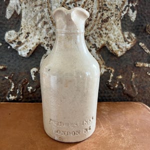 May include: A white ceramic mug with a black handle and the text "But First, Coffee" in a black, bold font. The mug is on a white surface. The mug is likely for hot beverages.