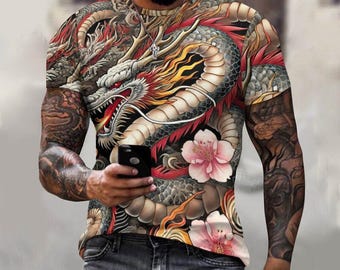 May include: A white short-sleeved t-shirt with a colorful dragon and floral print. The dragon is red, yellow, and black, and the flowers are pink and white.
