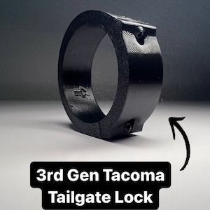 May include: Black plastic tailgate lock for a 3rd generation Tacoma truck.