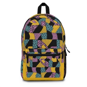 Peut inclure: Un sac à dos à motif patchwork jaune, noir, rose et bleu. Le sac à dos a un grand compartiment principal et une petite poche avant.