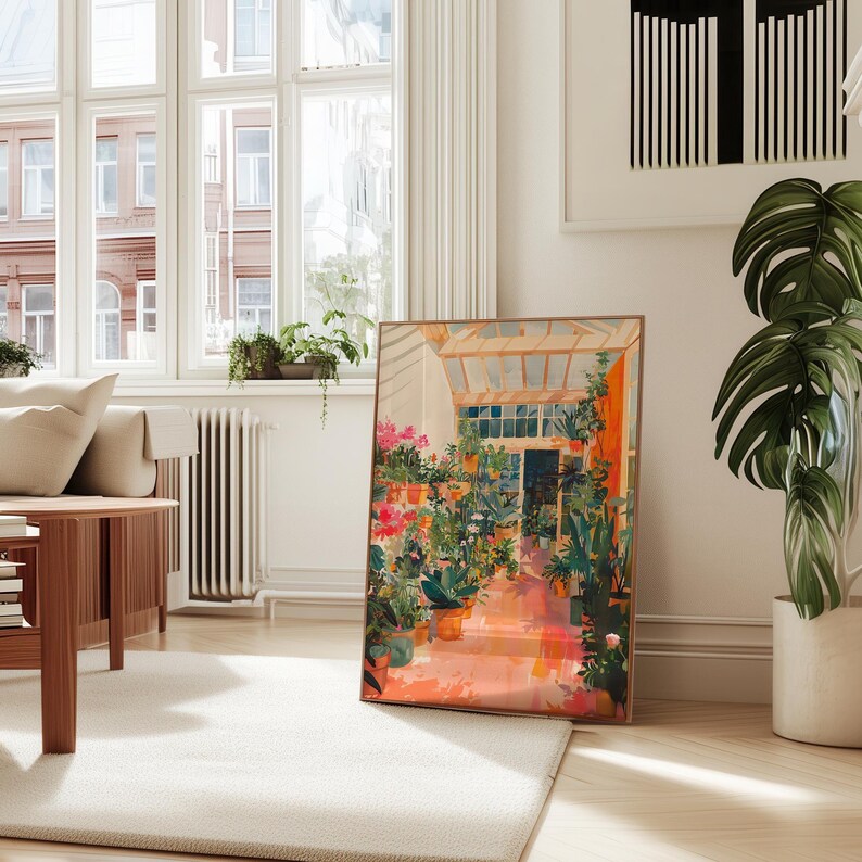 Puede incluir: Una impresi&oacute;n art&iacute;stica enmarcada que representa el interior de un invernadero soleado lleno de plantas y flores en macetas. La obra de arte presenta una paleta de colores c&aacute;lidos con tonos de naranja, rosa y verde, creando una escena vibrante. La impresi&oacute;n se muestra sobre una alfombra blanca.