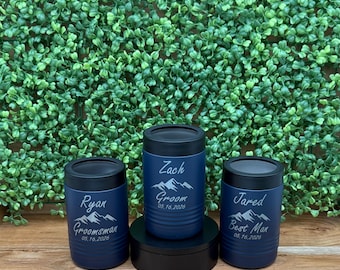 May include: Three blue and black insulated beverage holders with mountain and text designs. The holders read "Zach Groom 05.16.2026", "Ryan Groomsman 05.16.2026", and "Jared Best Man 05.16.2026".