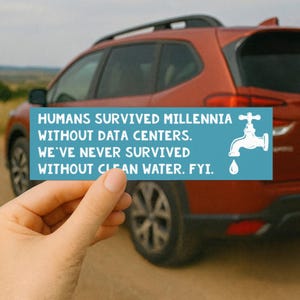 May include: A rectangular teal bumper sticker featuring white text that reads: HUMANS SURVIVED MILLENNIA WITHOUT DATA CENTERS. WE'VE NEVER SURVIVED WITHOUT CLEAN WATER. FYI. A white graphic of a water faucet and a single drop is on the right.