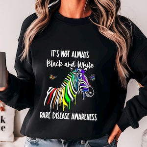May include: Black sweatshirt with a rainbow zebra and the text "It's not always black and white. Rare disease awareness."