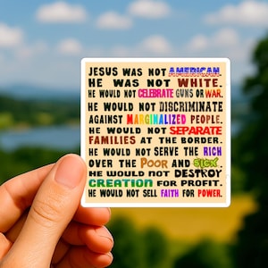 Pode incluir: Um adesivo quadrado segurado por uma mão, com texto em várias cores. O texto diz: "JESUS NÃO ERA AMERICANO. ELE NÃO ERA BRANCO. ELE NÃO CELEBRARIA ARMAS OU GUERRA..." O fundo é uma vista desfocada da natureza.