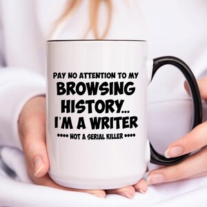 May include: White ceramic coffee mug with a black handle and black rim. The mug has black text that reads "PAY NO ATTENTION TO MY BROWSING HISTORY... I'M A WRITER.... NOT A SERIAL KILLER...."