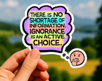 Op de afbeelding: Een gestanste sticker in de vorm van een gedachtenwolk met een regenboogverloop als achtergrond. De zwarte tekst luidt: THERE IS NO SHORTAGE OF INFORMATION. IGNORANCE IS AN ACTIVE CHOICE. Een klein rond icoontje van een denkend gezicht is bijgevoegd.
