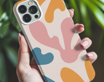 Pode incluir: Uma capa de telefone branca com um design abstrato colorido com formas rosa, azul e amarelo. A capa tem um recorte para a câmera do telefone.